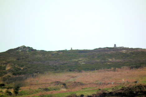 A cairn (on the right, with a modern trig point on it) on Watch Croft, as seen from downhill at Men Scryfa. Middle, a menhir, placed to be seen from Men Scryfa. Left, a natural crag, but energetic.